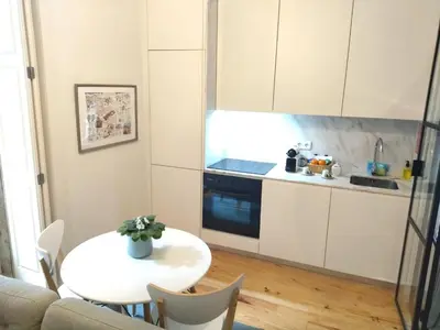 a small kitchen with a table and a white kitchen at Santa Catarina Patio Apartment - with washer machine in Porto