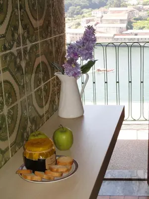a table with a plate of food and a vase with flowers at Oportobestview in Porto