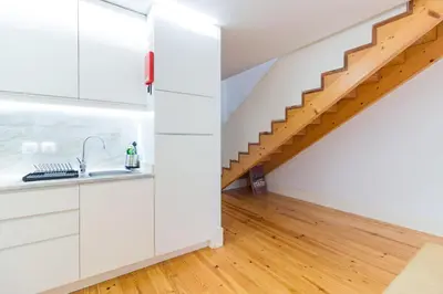 a kitchen with white cabinets and a staircase at ON Apartments - Palace - Free Parking in Porto
