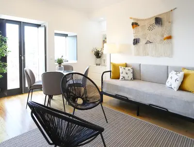 a living room with a couch and a table and chairs at HM - OPorto City View in Porto