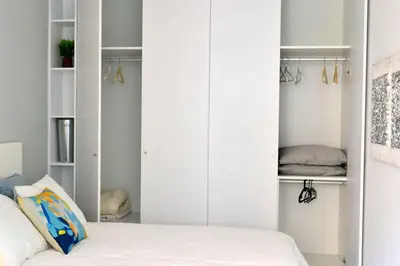 a bedroom with white cabinets and a bed at Downtown Porto Spot in Porto