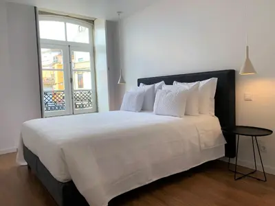 a bedroom with a large white bed with a window at RIBEIRA OPORTO APARTMENT (NEW) in Porto