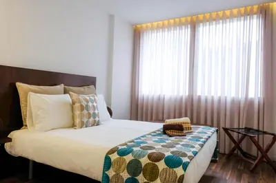 a bedroom with a bed with a large window at Vintage Porto in Porto