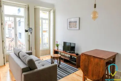 a living room with a couch and a tv and a table at Simply Porto in Porto