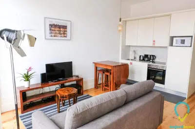 a living room with a couch and a kitchen at Simply Porto in Porto