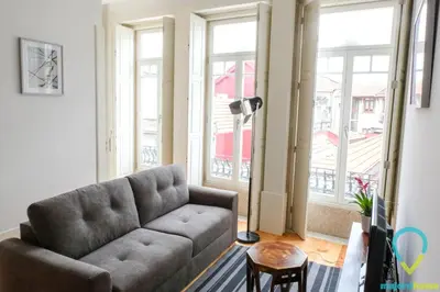 a living room with a couch and large windows at Simply Porto in Porto