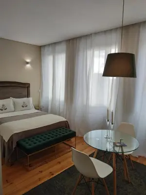a bedroom with a bed and a table and a chair at ML Apartments Republic in Porto