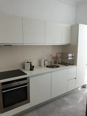 a white kitchen with white cabinets and a sink at Lux Ribeira - ALL INCLUDED in Porto