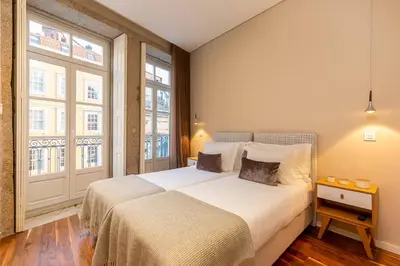 a bedroom with a bed and two windows at RS Porto Historic Center in Porto