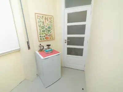 a bathroom with a white door and a small refrigerator at Oporto Guest Alegria Flat Downtown in Porto