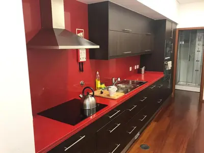 a red kitchen with a sink and a stove at Metro Heroismo Residence in Porto
