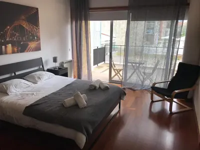 a bedroom with a bed and a chair and a window at Metro Heroismo Residence in Porto