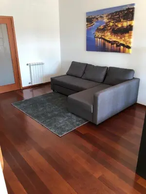 a living room with a couch and a painting on the wall at Metro Heroismo Residence in Porto