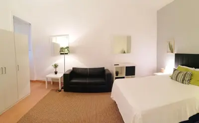 a bedroom with a bed and a black chair at Downtown Porto Spot - 2 bedrooms in Porto