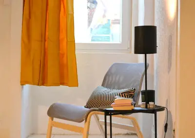 a chair sitting next to a table with a lamp at Downtown Porto Spot - 2 bedrooms in Porto