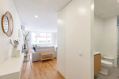 a white living room with a couch and a toilet at Oporto Palace Apartments in Porto