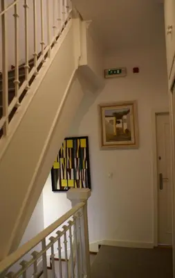 a staircase in a house with a painting on the wall at O'Porto Seven - Guest House in Porto