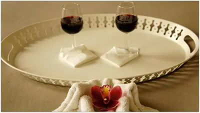 two glasses of wine and a flower on a plate at Hostel Gaia Porto in Vila Nova de Gaia