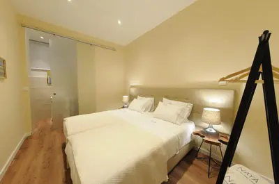 a bedroom with a white bed and a tripod at Naya-Downtown Guesthouse in Porto
