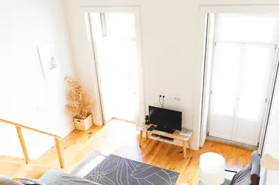 a living room with a couch and a tv at Aposentus -Romantic Mezzanine Apartment With a Balcony in Porto