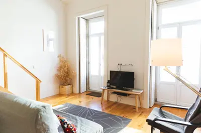 a living room with a couch and a tv at Aposentus -Romantic Mezzanine Apartment With a Balcony in Porto