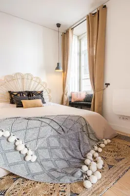 a bedroom with a large bed with a blanket on it at Little Capeli in Porto