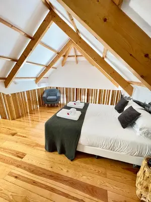 a bedroom with a bed in a room with wooden floors at 1118 Lofts in Porto