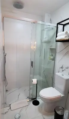 a white bathroom with a shower and a toilet at Porto Belo Bolhao Apartments - Free Parking in Porto