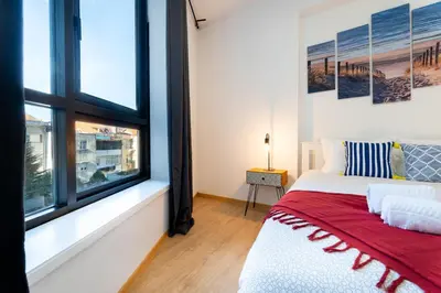 a bedroom with a bed and a large window at Porto Belo Bolhao Apartments - Free Parking in Porto