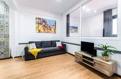 a living room with a couch and a tv at Porto Belo Bolhao Apartments - Free Parking in Porto