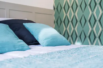 a bed with two blue pillows on it at Casas das Caldeiras in Porto
