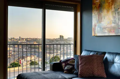 a living room with a couch and a large window at Porto Cathedral in Porto