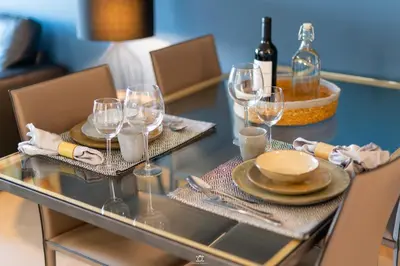 a glass table with wine glasses and plates on it at Porto Cathedral in Porto