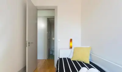 a white room with a bed with a yellow pillow at A da Maria Ildefonso in Porto