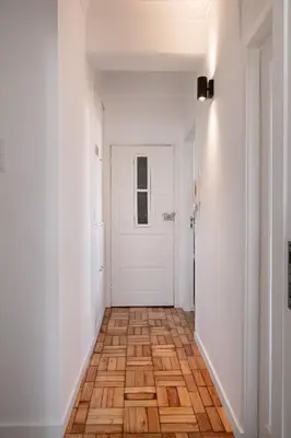 a hallway with a white door and a wooden floor at Poveiros Terrace - 3BR Downtown apartment with AC in Porto