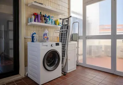 a washing machine in a room with a window at Poveiros Terrace - 3BR Downtown apartment with AC in Porto