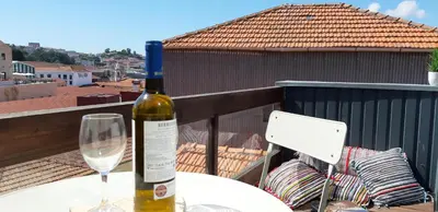 a bottle of wine sitting on a table with a glass at Modern house - air cond, free parking, breakfast, by Porto with Love LDA in Vila Nova de Gaia