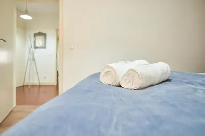 two rolled towels sitting on top of a bed at Riverside (with 3 Bedrooms) by JC in Porto