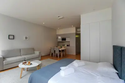a bedroom with a bed and a couch and a table at Santa Catarina Downtown I in Porto