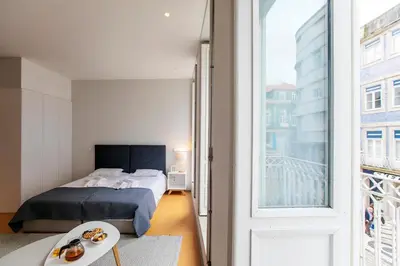 a bedroom with a bed and a large window at Santa Catarina Downtown I in Porto