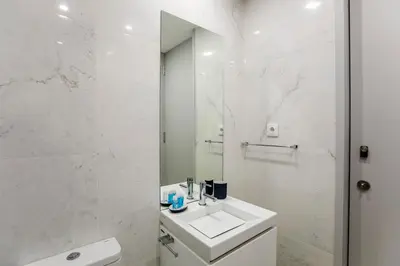 a white bathroom with a sink and a mirror at Santa Catarina Downtown I in Porto