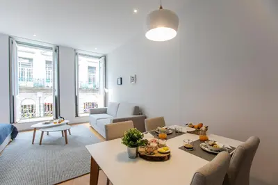 a living room with a table and chairs and a couch at Santa Catarina Downtown I in Porto