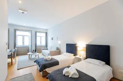 a bedroom with two beds and a living room at Santa Catarina Downtown II in Porto