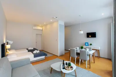 a living room with a bed and a dining room at Santa Catarina Downtown II in Porto