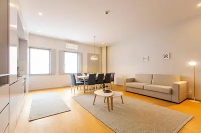 a kitchen and living room with a couch and a table at Santa Catarina Downtown III in Porto