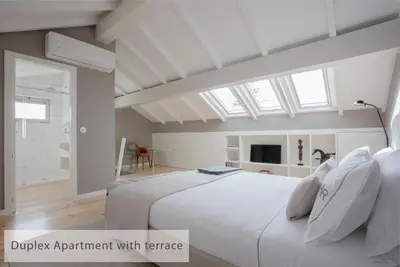 a bedroom with a large white bed and a window at Alegria Residence in Porto