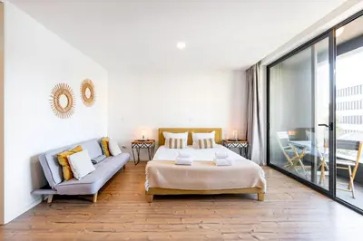 a bedroom with a bed and a couch and a table at VIVA In the MOOD in Porto