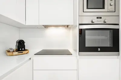 a white kitchen with a stove and a microwave at VIVA In the MOOD in Porto