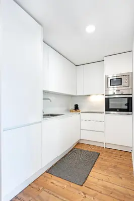 a kitchen with white cabinets and a rug at VIVA In the MOOD in Porto