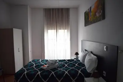 a bedroom with a bed and a window at Guest House Henrique VIII in Porto
